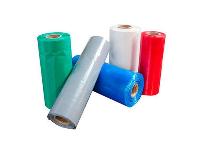 Rollos de film plástico de diferentes colores se apilan uno encima del otro sobre un fondo blanco.