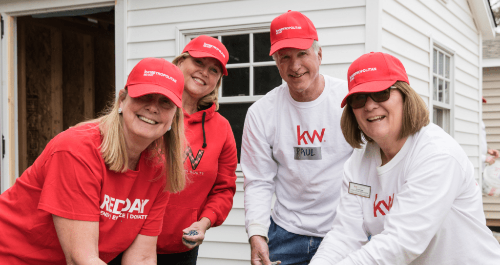 A group of people wearing red hats and white shirts are standing in front of a white house.