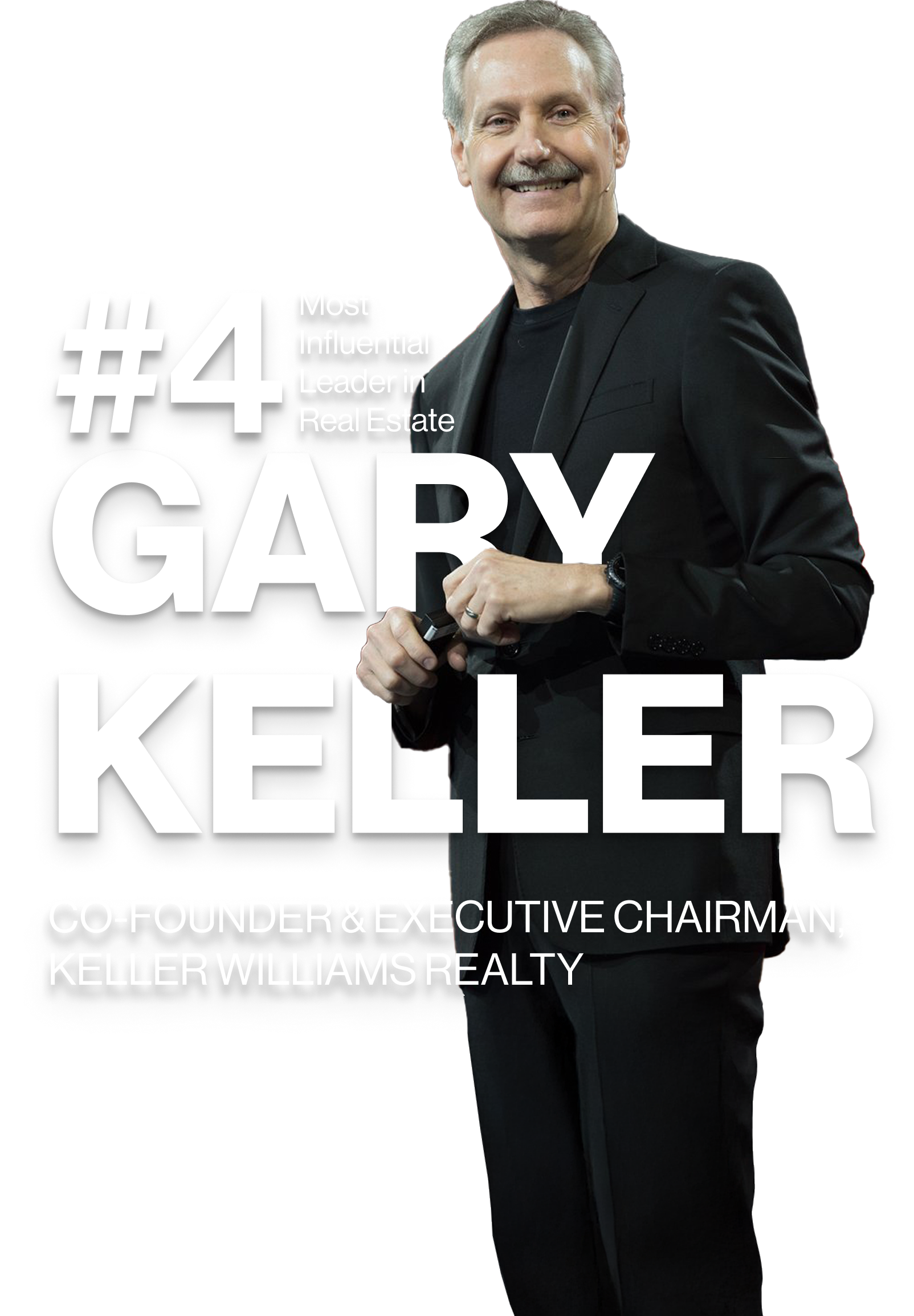 A man in a suit is holding a camera and smiling.