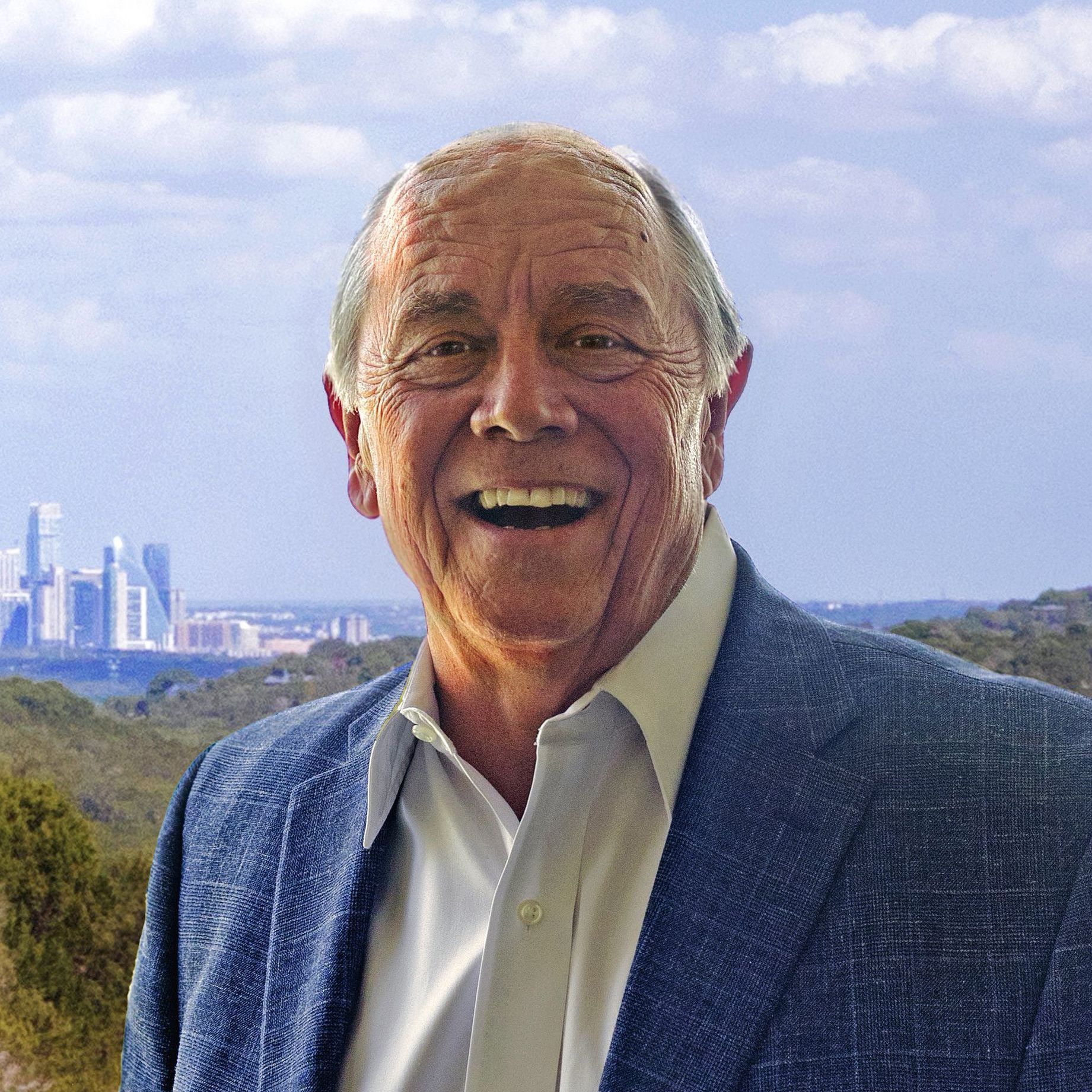 A man in a blue jacket and white shirt is smiling in front of a city skyline