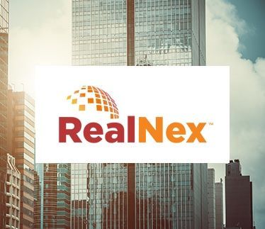 A realnex logo is displayed in front of a city skyline