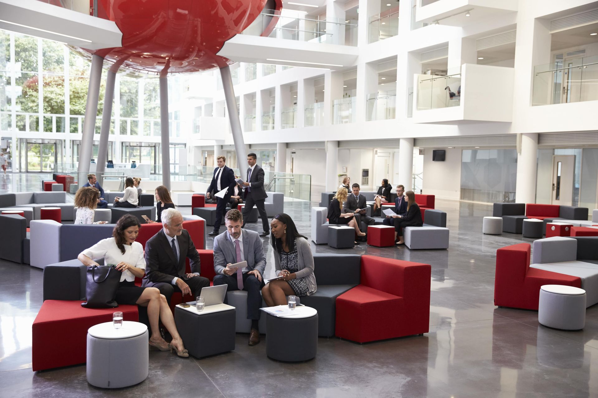 A group of people are sitting in a lobby of an office building.