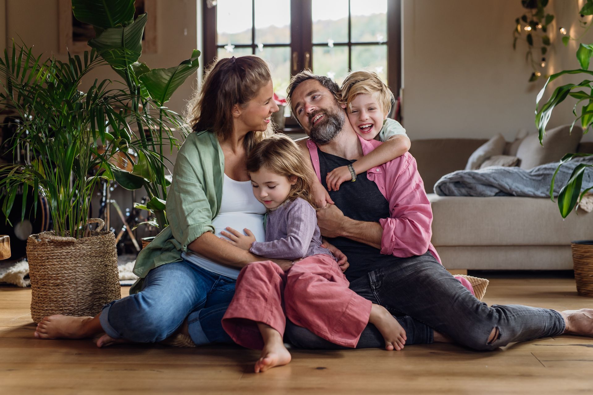 A family is sitting on the floor in a living room.