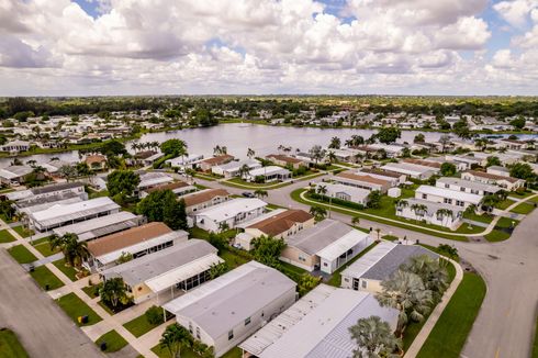 An aerial view of a mobile home park with a lake in the background.