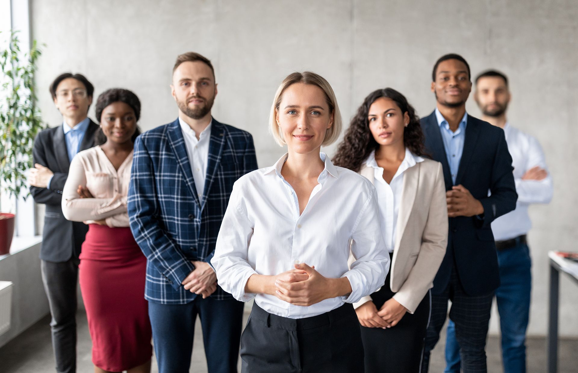 A group of business people standing next to each other in an office.
