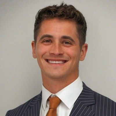 A man in a suit and tie is smiling for the camera.