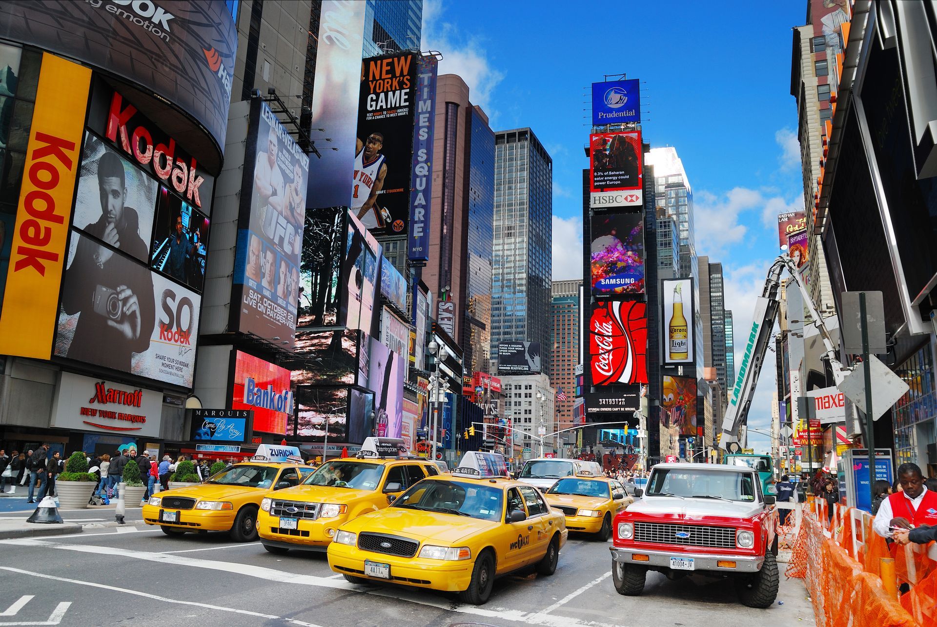 A busy city street with a kodak sign in the background