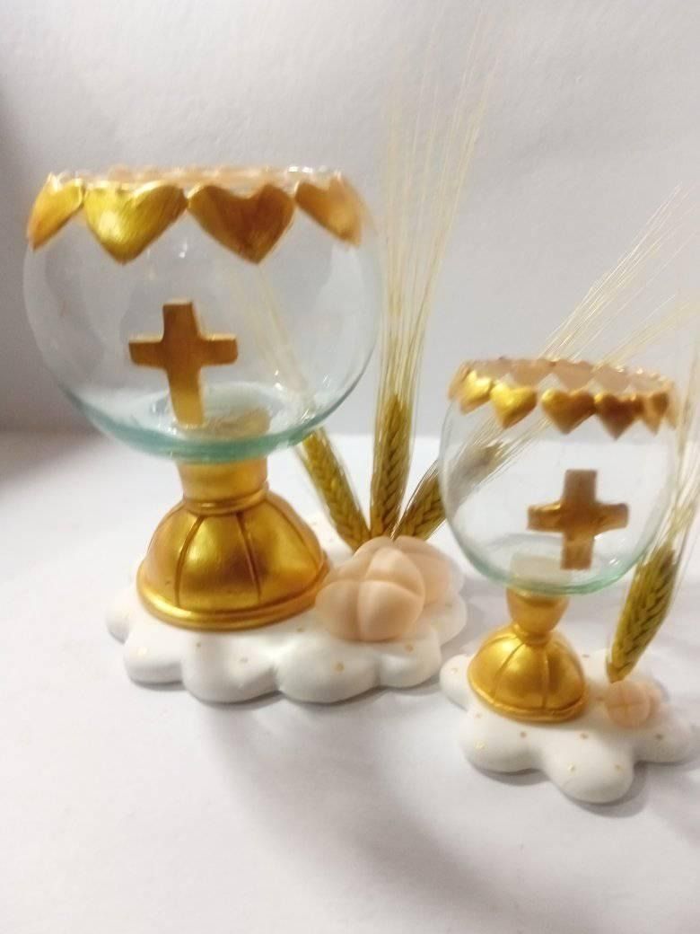 Dos cálices de oro y cristal sobre una base en forma de nube, con un diseño de cruz y espigas de trigo.