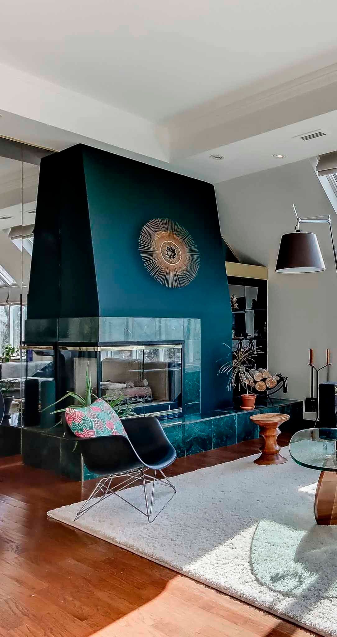 Un chemin de pierre mène à un feuillage d'automne, bordé par le bardage en bois patiné d'un bâtiment.