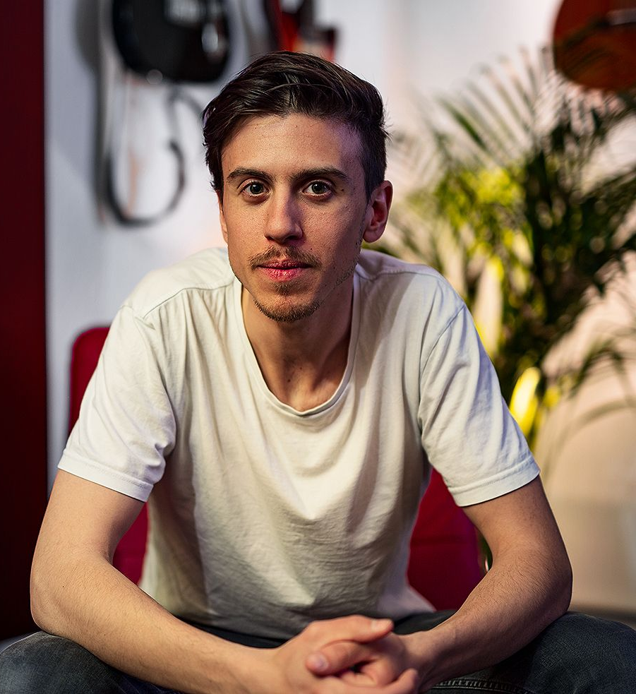 Ein Mann in einem weißen Hemd sitzt in einem Studio