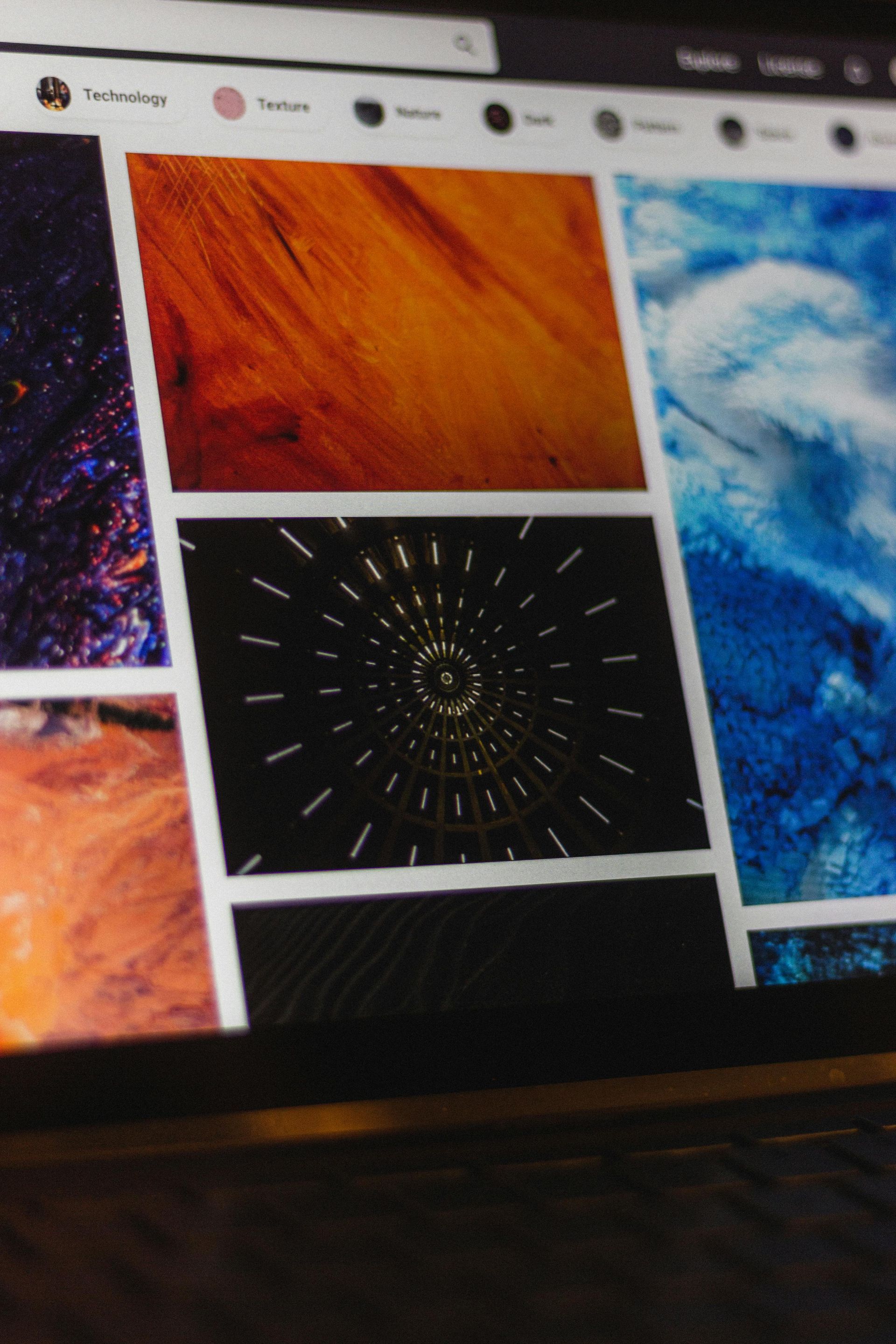 Auf dem Bildschirm eines Laptops wird ein Raster aus abstrakten, farbenfrohen Hintergrundbildern angezeigt, darunter eine goldene Holzstruktur und ein schwarzer Tunnel.