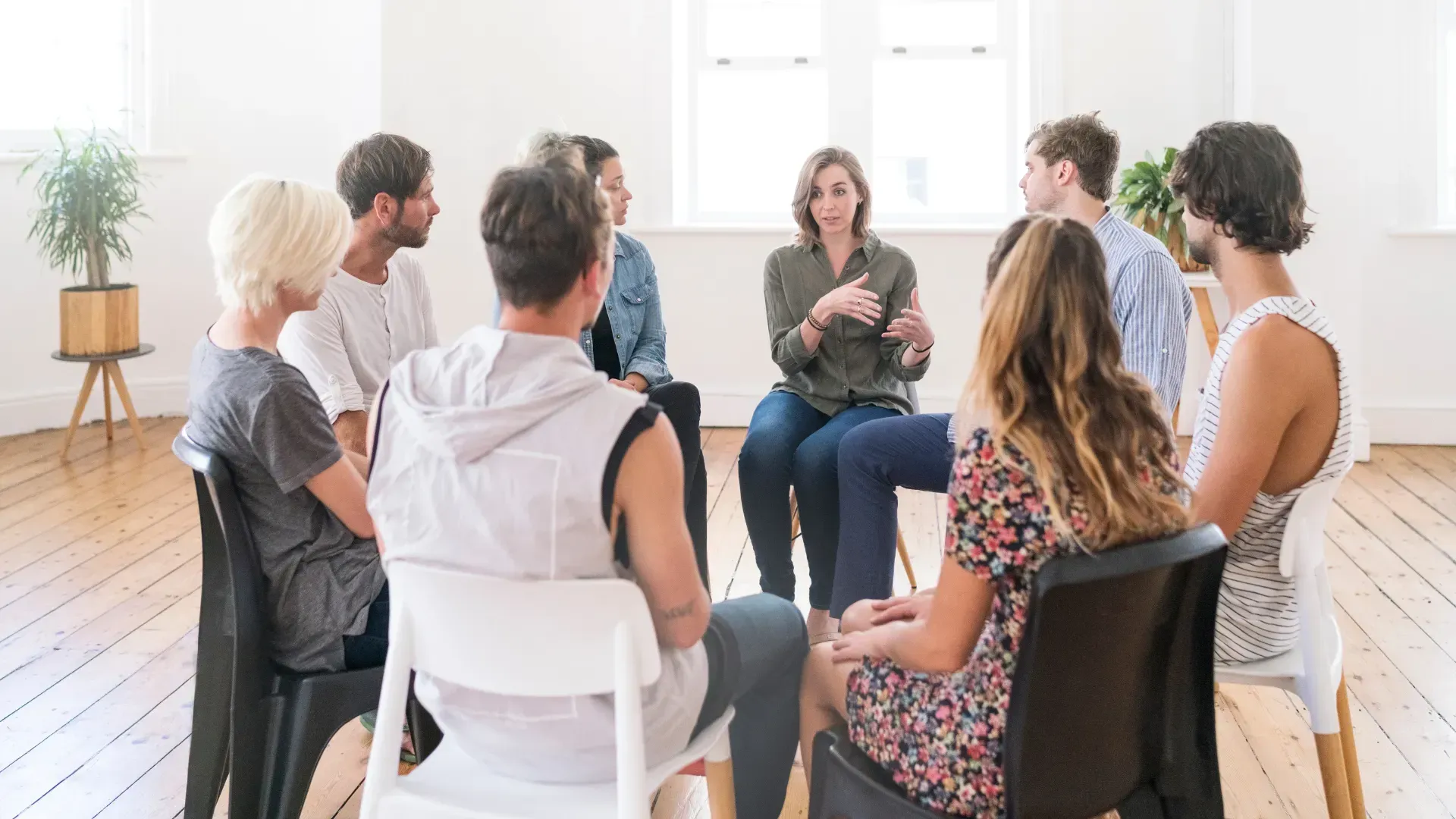 A group of people are sitting in a circle in a room.