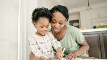 A woman and a child are sitting at a table.