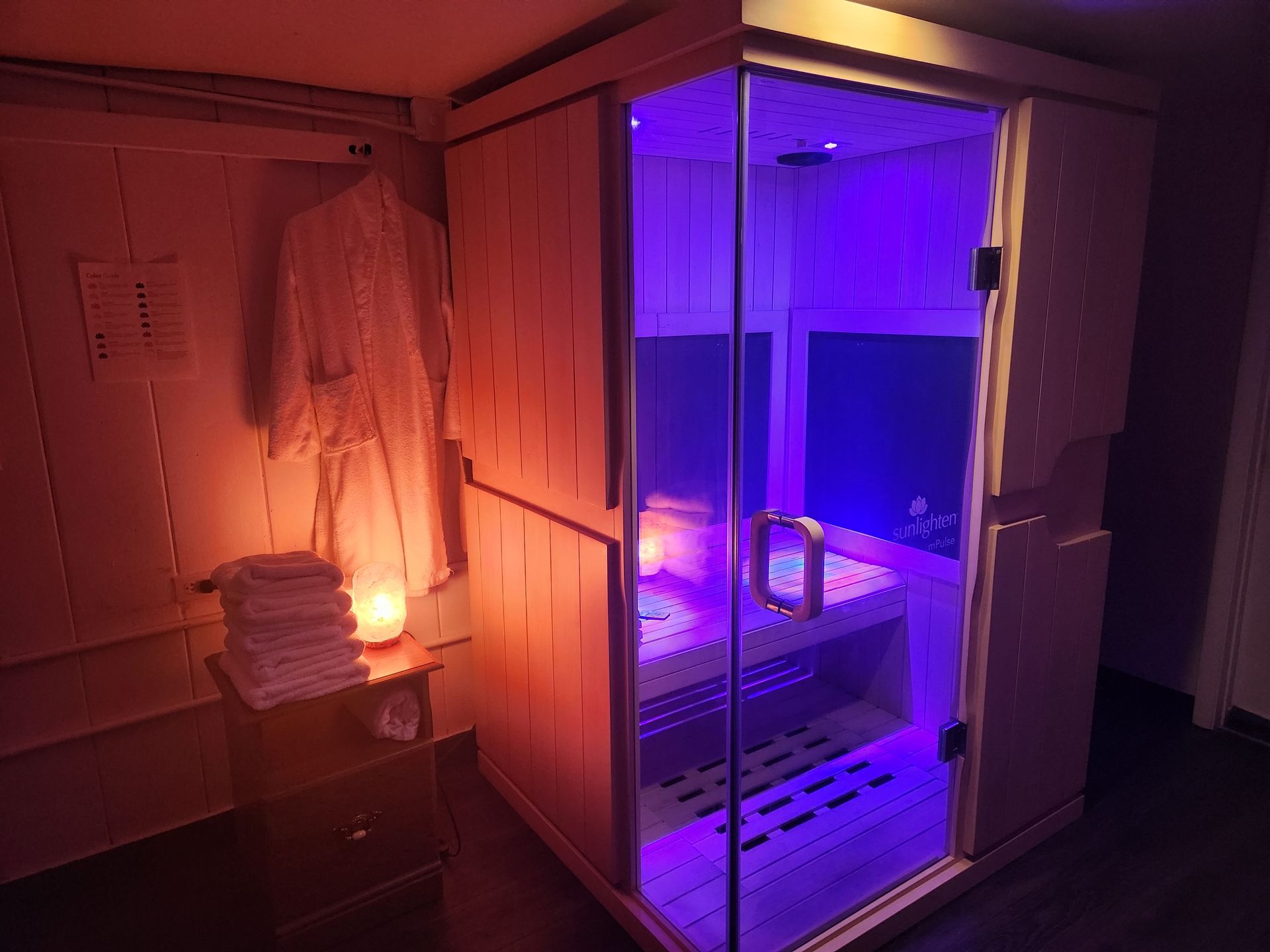 A wooden sauna with red lights on the walls.