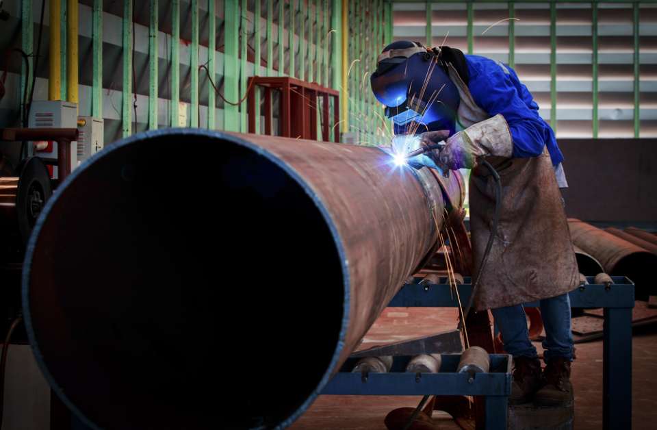 man welding pipes