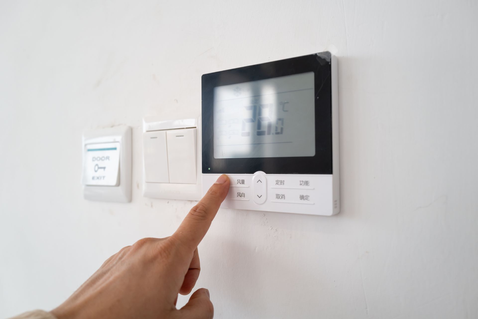 Hand Presses a Button on A White Digital Thermostat — Breezy Point, MN — JM Heating & Air Hand Presses a Button on A White Digital Thermostat — Breezy Point, MN — JM Heating & Air