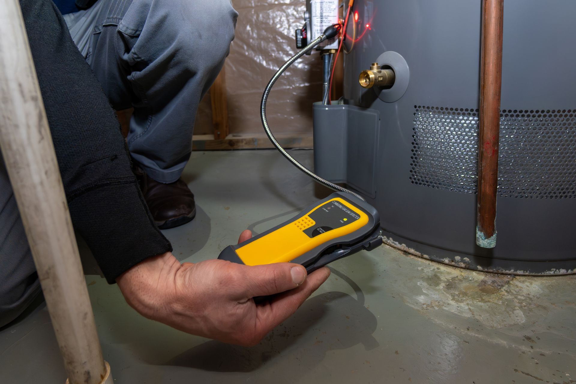 Inspecting a Gray Water Heater in A Basement — Breezy Point, MN — JM Heating & Air Inspecting a Gray Water Heater in A Basement — Breezy Point, MN — JM Heating & Air