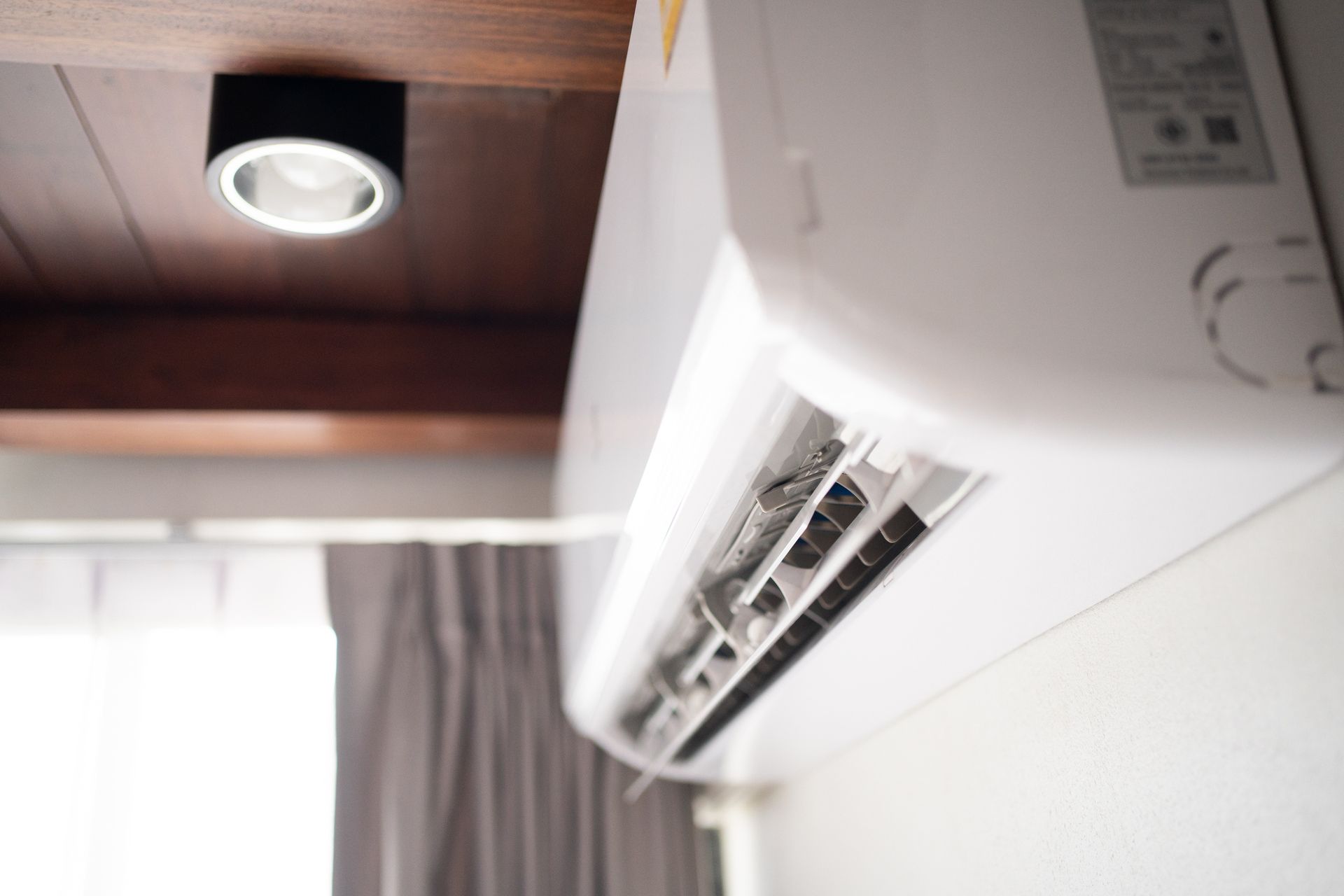 White Air Conditioning Unit Mounted on A Wall — Breezy Point, MN — JM Heating & Air White Air Conditioning Unit Mounted on A Wall — Breezy Point, MN — JM Heating & Air