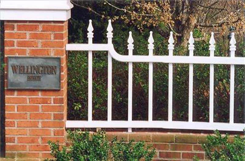 Fence Designs — White Fence Connected to a Brick Wall in Winston-Salem, NC