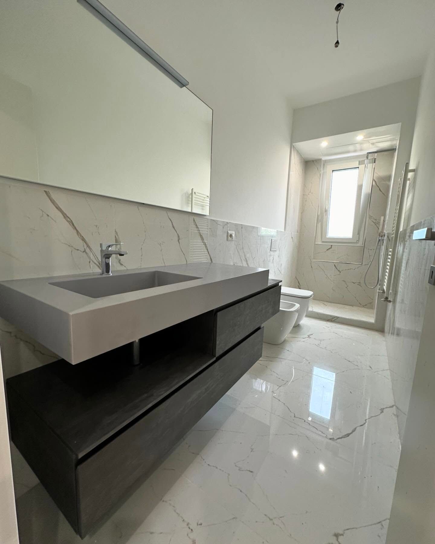 Un bagno con lavandino, WC e specchio