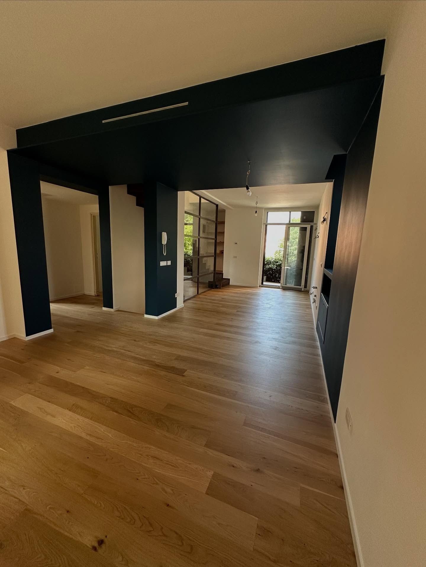 Un soggiorno con pavimento in legno e soffitto blu.