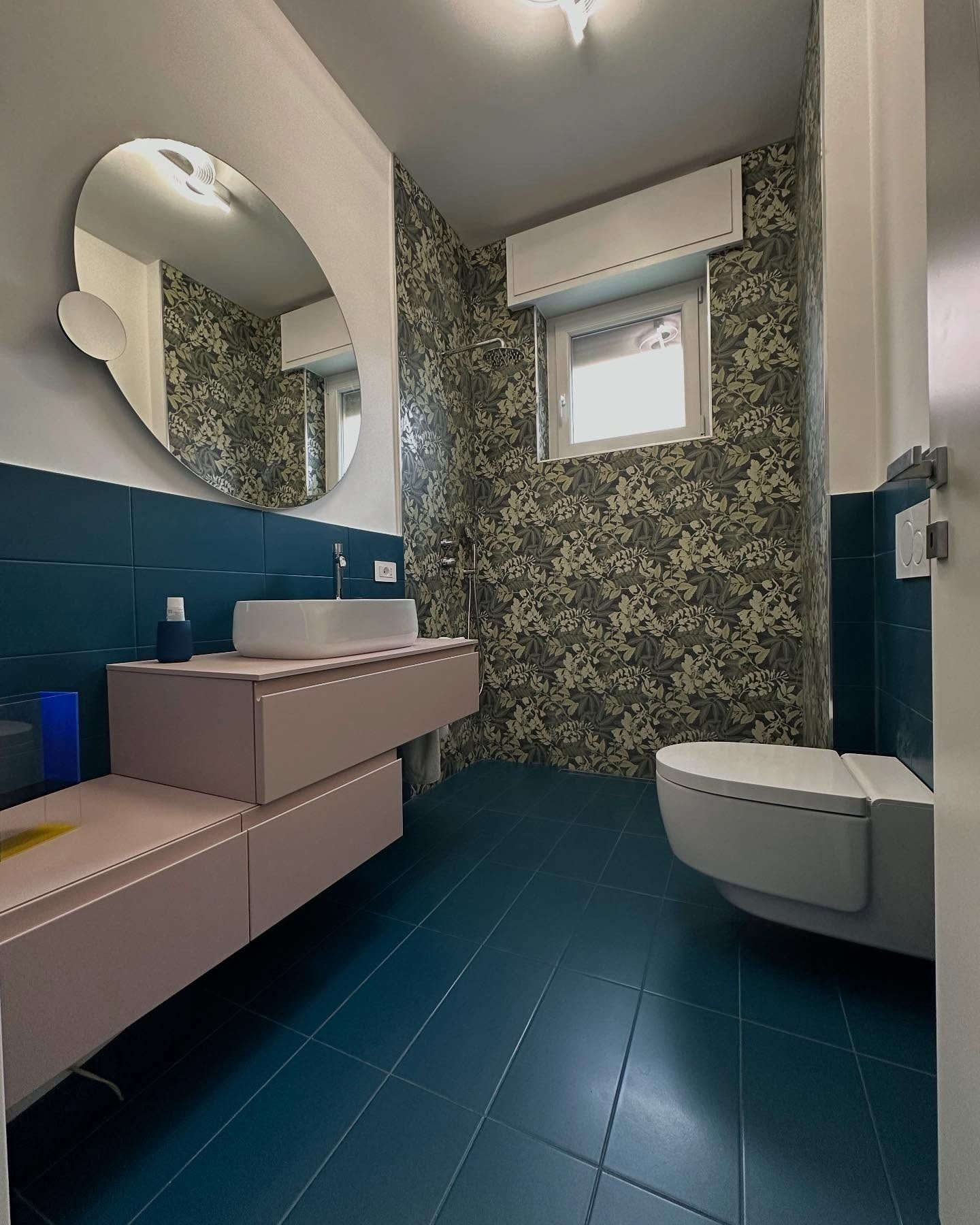 Un bagno con lavandino, WC e specchio