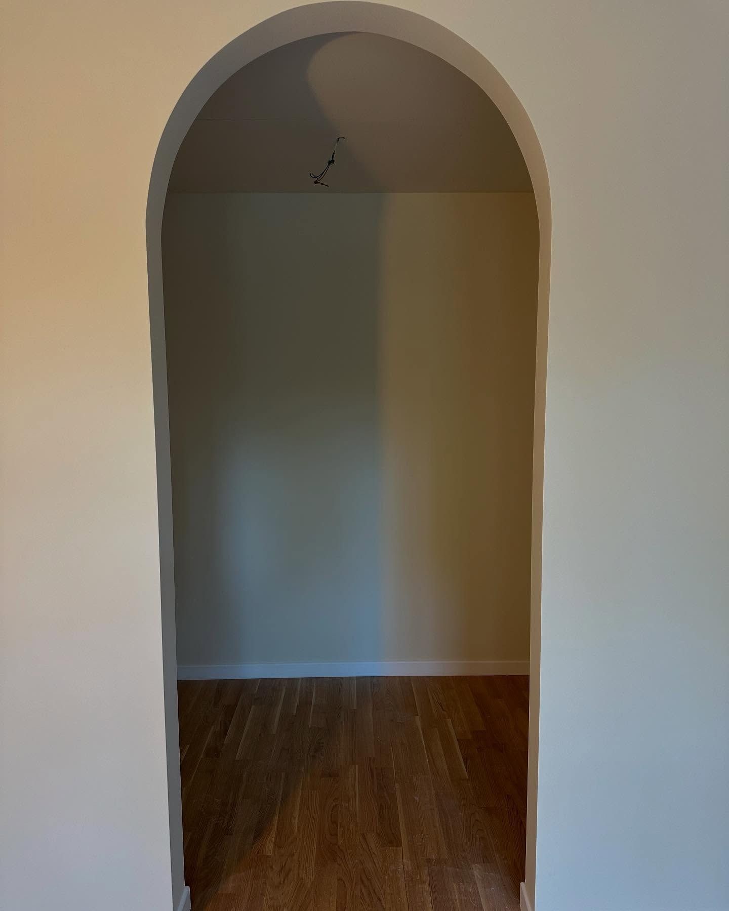 Una stanza vuota con un arco che conduce al soffitto