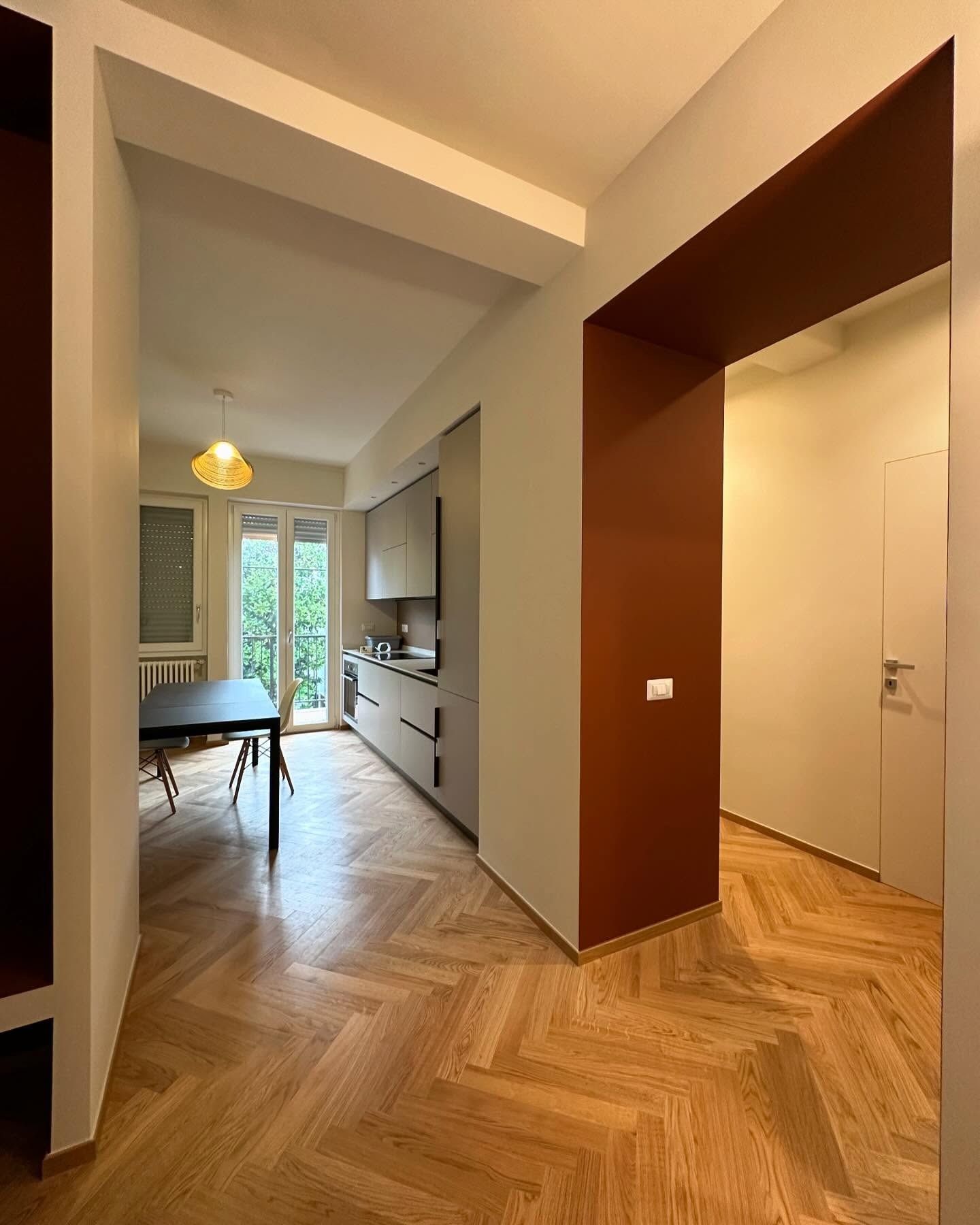 Un corridoio che conduce a una cucina con tavolo e sedie