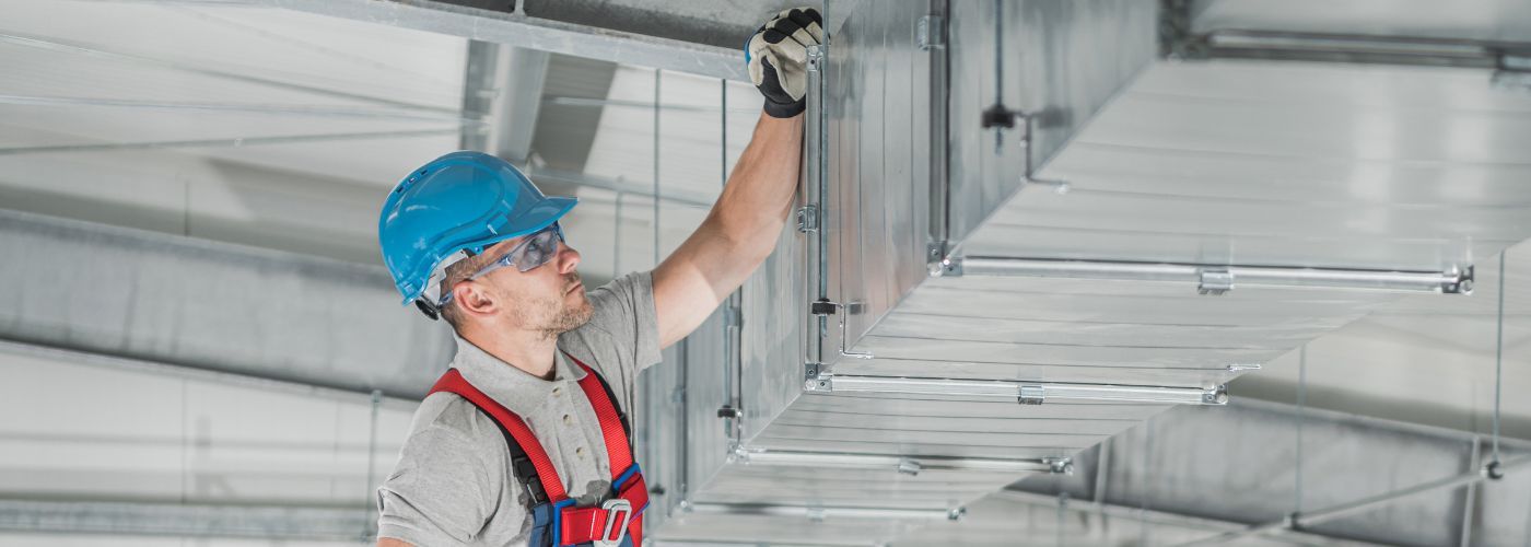 HVAC technician in Denver performing spring maintenance.