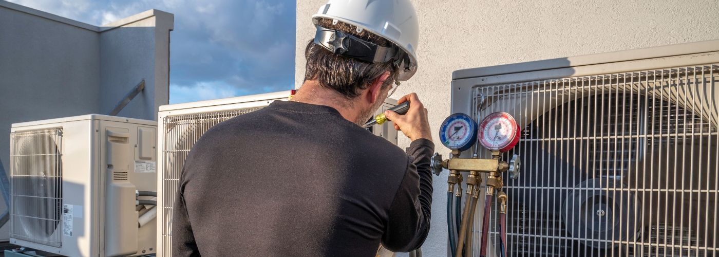 man fixing hvac system on hot summer day