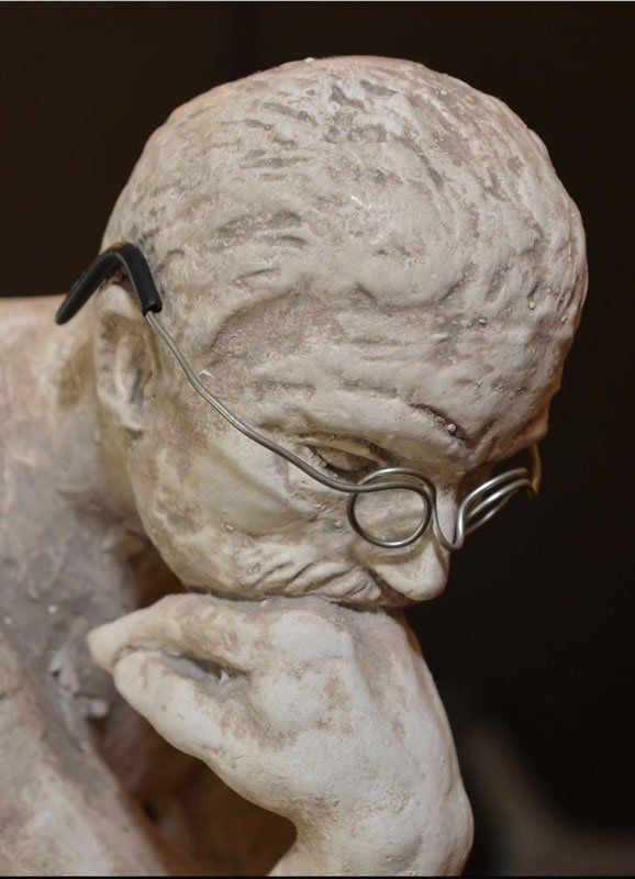 Statue of Man Resting Face on Hand & Wearing Wire Glasses