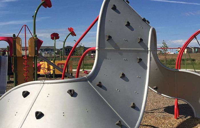 A playground with a slide and a climbing wall