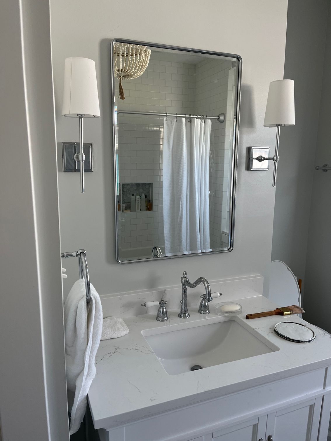 A bathroom with a sink , mirror and shower curtain.