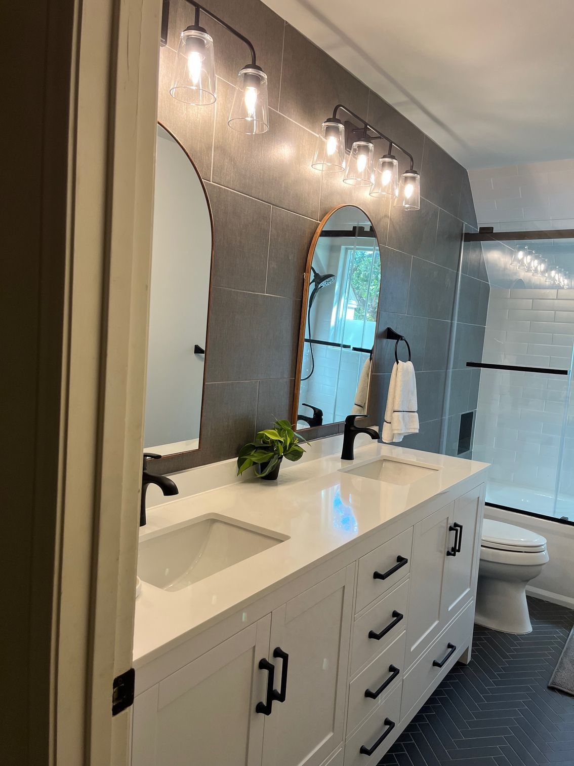 A bathroom with two sinks , a toilet , and a mirror.