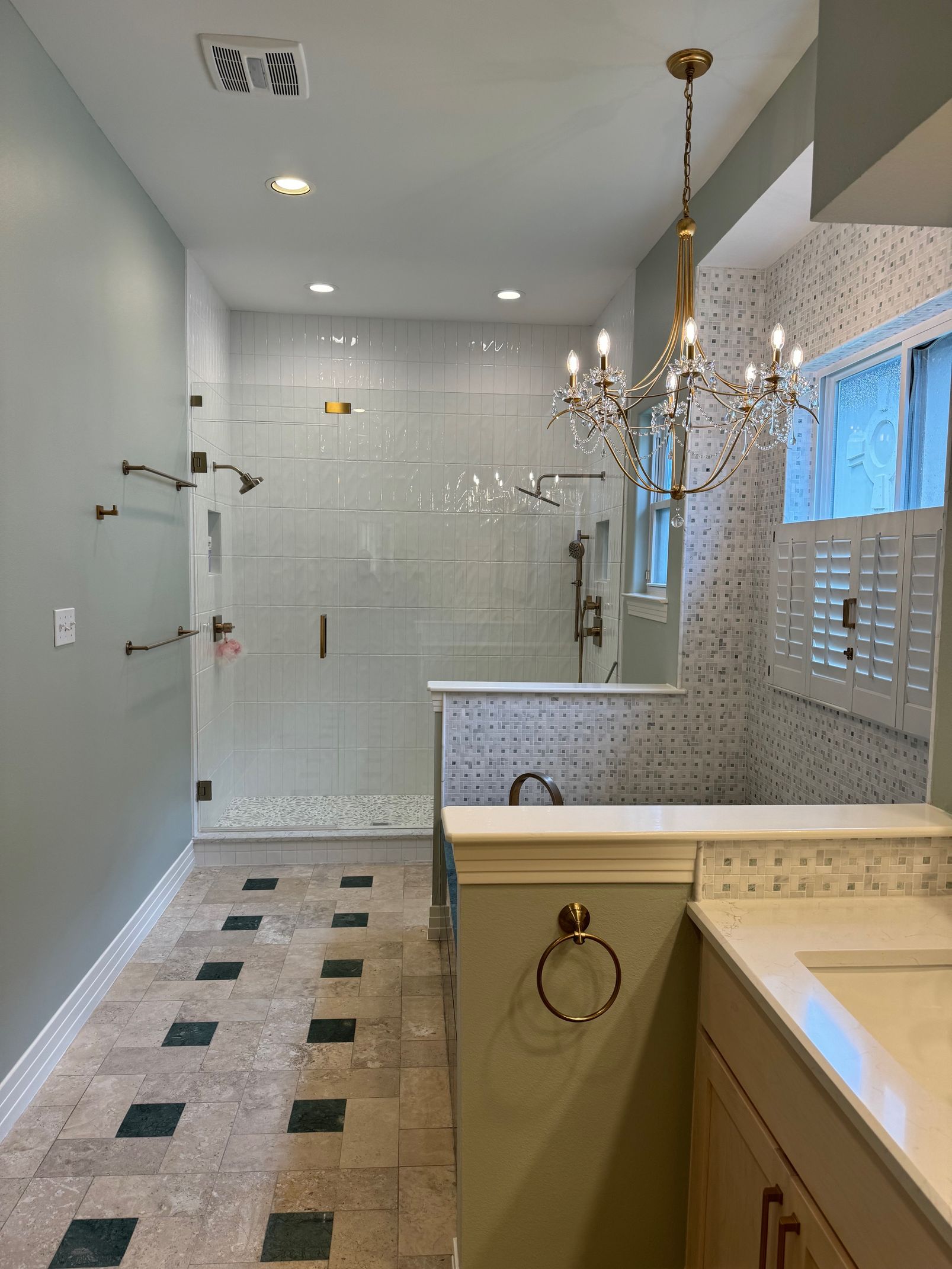A bathroom with a walk in shower and a sink.