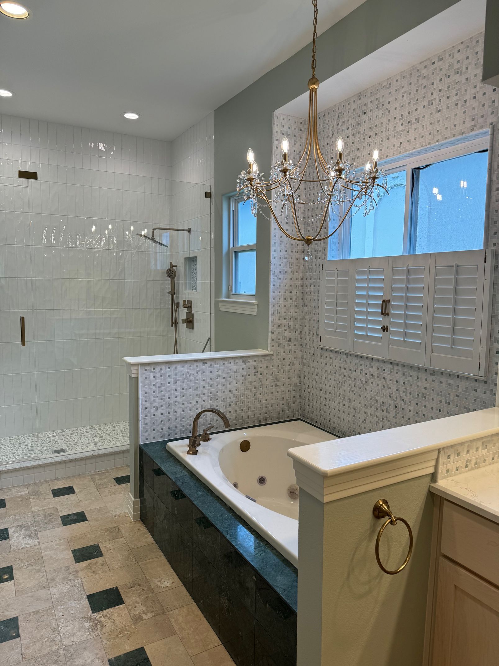 A bathroom with a jacuzzi tub and a chandelier hanging from the ceiling.