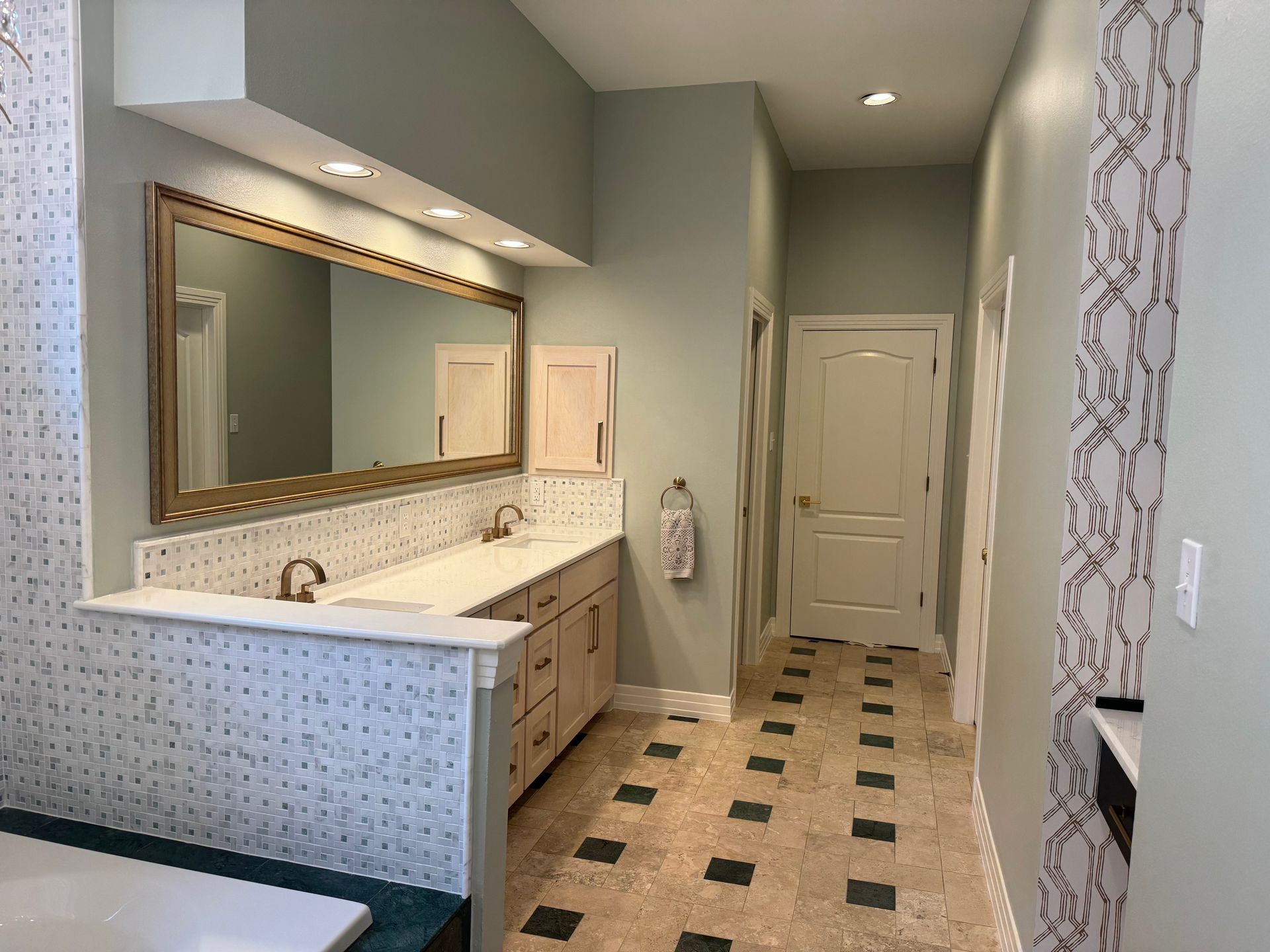 A bathroom with two sinks and a large mirror.