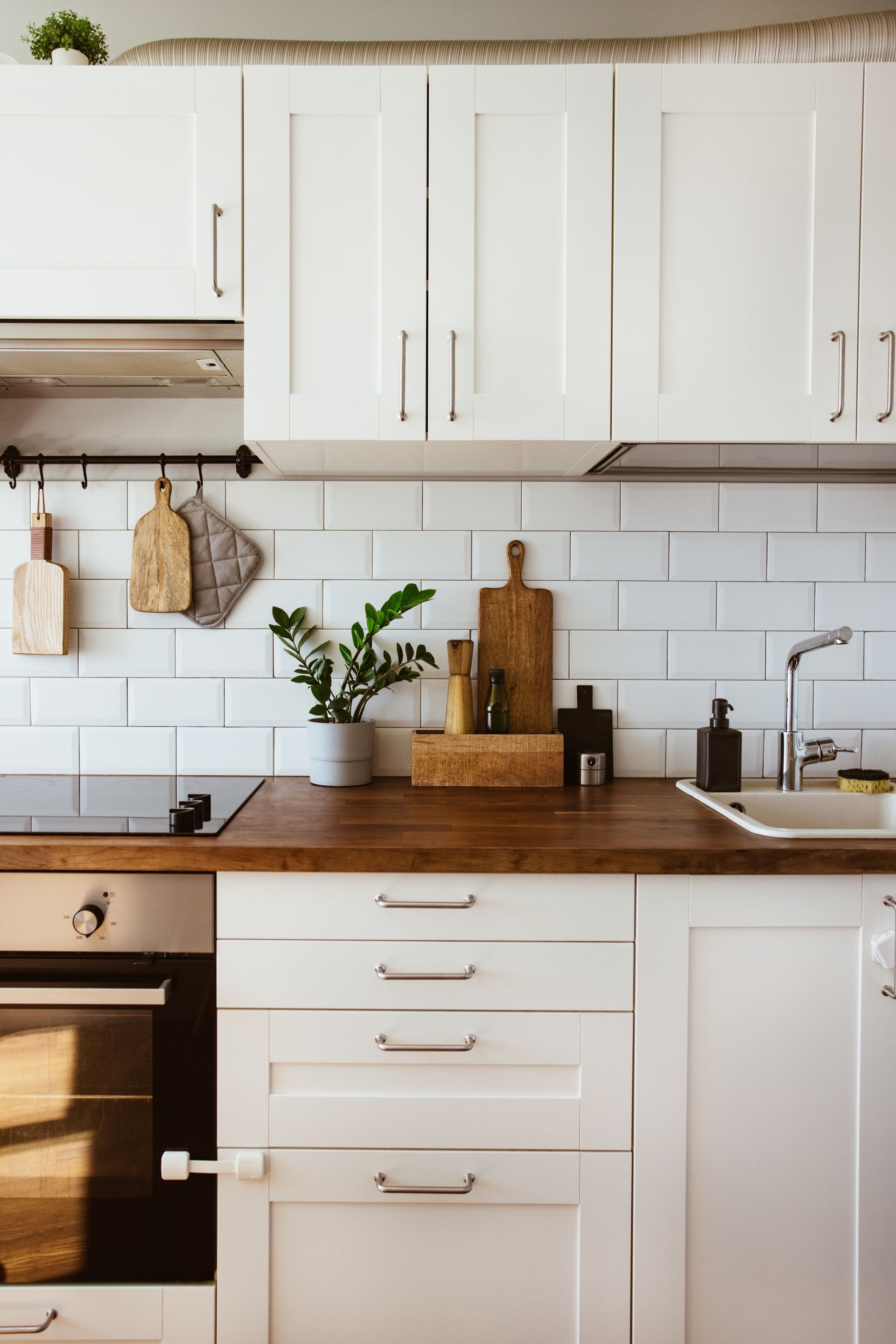 a kitchen with white cabinets and wooden counter tops