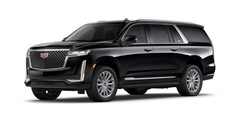 Couple in a black vintage car, smiling, driving towards the viewer.