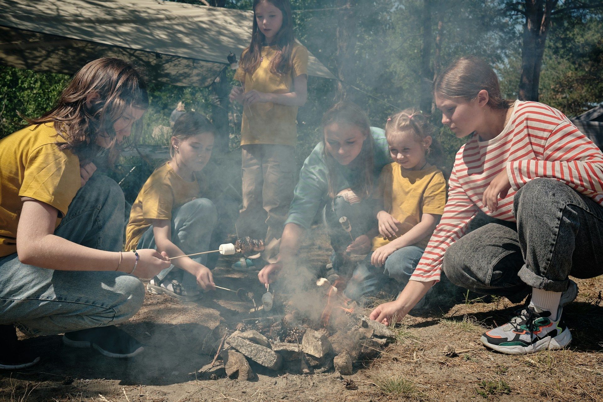 family roasting s'mores over campfire