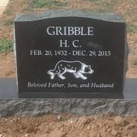 Black memorial plaque with a dog portrait and the text “JR 2000–2015”