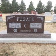 Maroon Fugate family gravestone in a cemetery, with trees and other headstones in the background