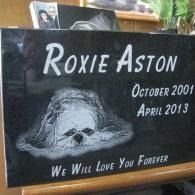 Black memorial plaque for Roxie Aston with sleeping dog sketch, dates October 2001-April 2013, “We will love you forever”