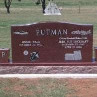 Maroon Putman cemetery headstone with engraved names and a small photo plaque on a grassy plot