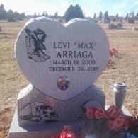 Heart-shaped gravestone for Levi “Max” Arriaga with flowers in a cemetery