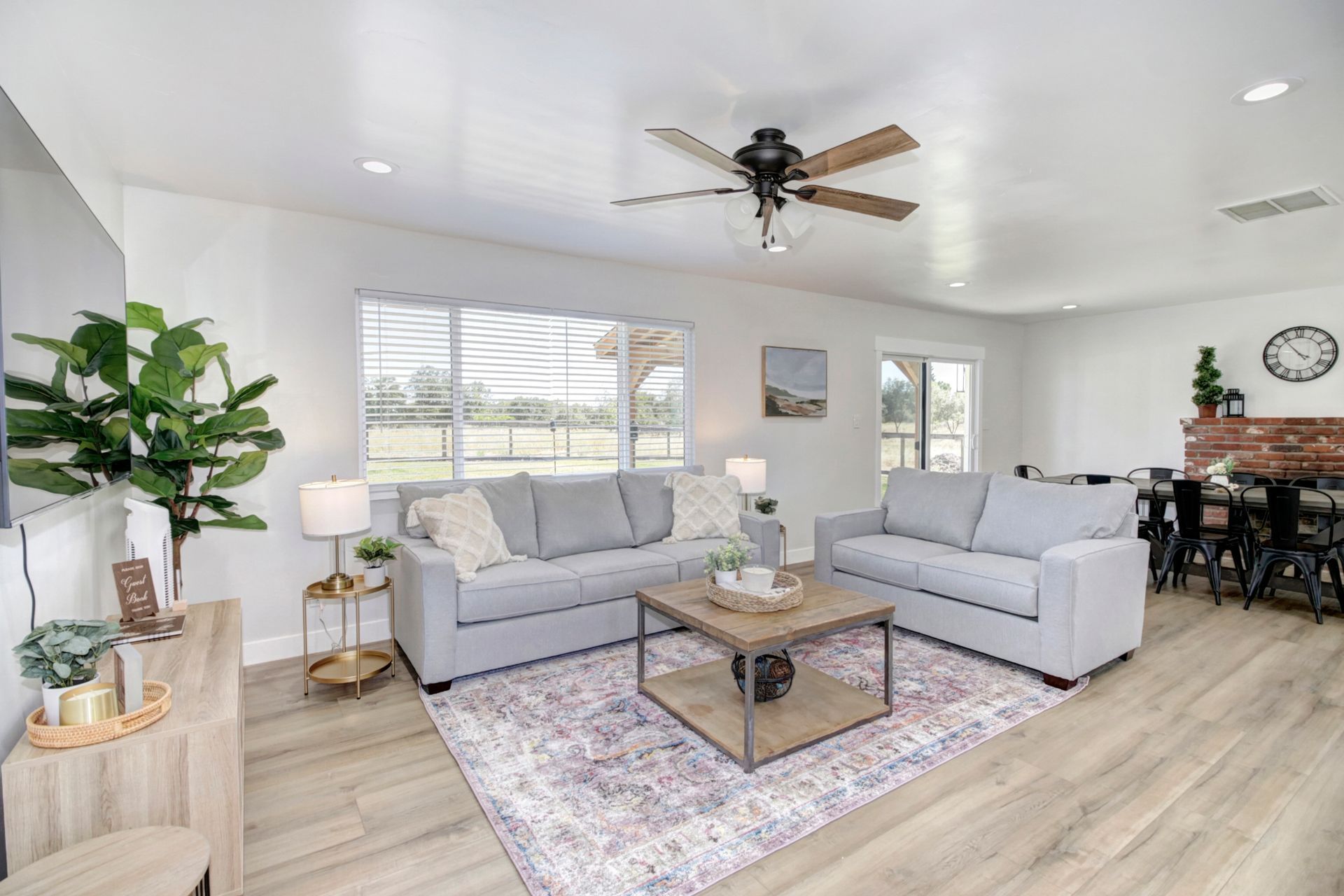 A living room with two couches , a coffee table , and a ceiling fan.