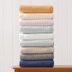 A stack of towels is sitting on top of a wooden table.
