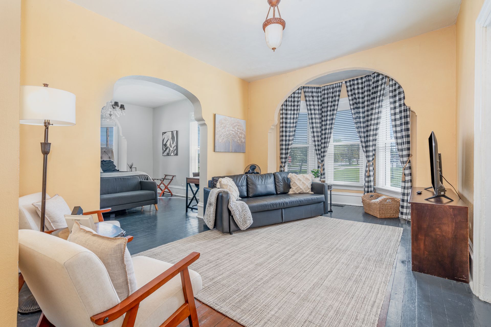 A living room with a couch , chair , lamp and television.
