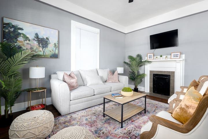 A living room with a couch , chairs , coffee table and fireplace.