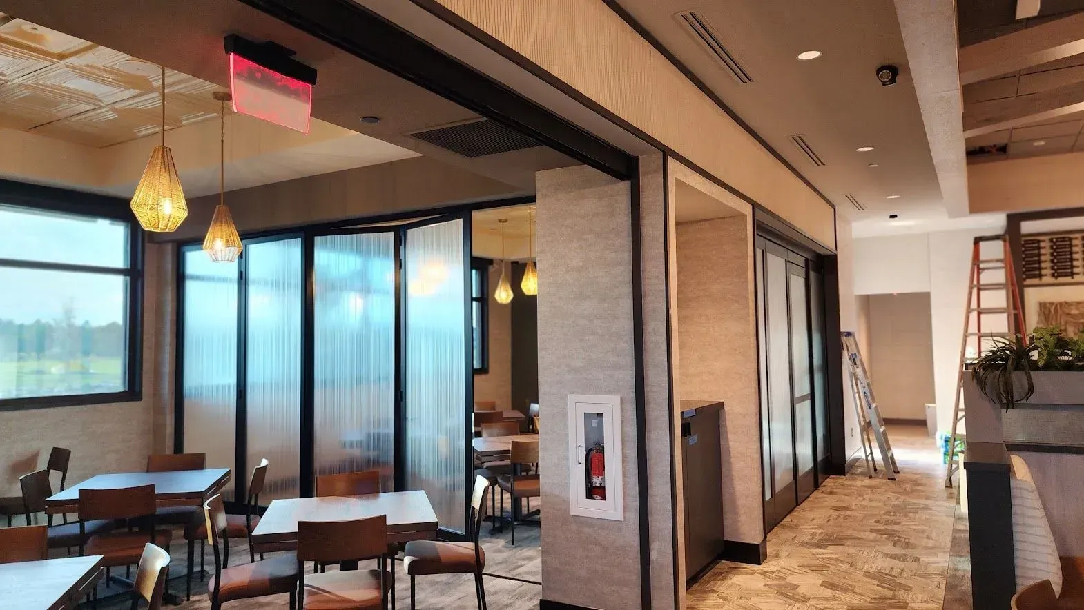 A restaurant with tables and chairs and sliding glass doors.